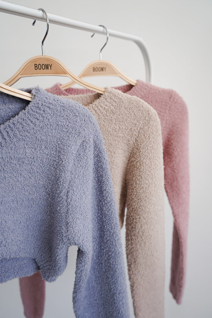 A cropped cozy sweater featuring a scoop neckline and long sleeves.
