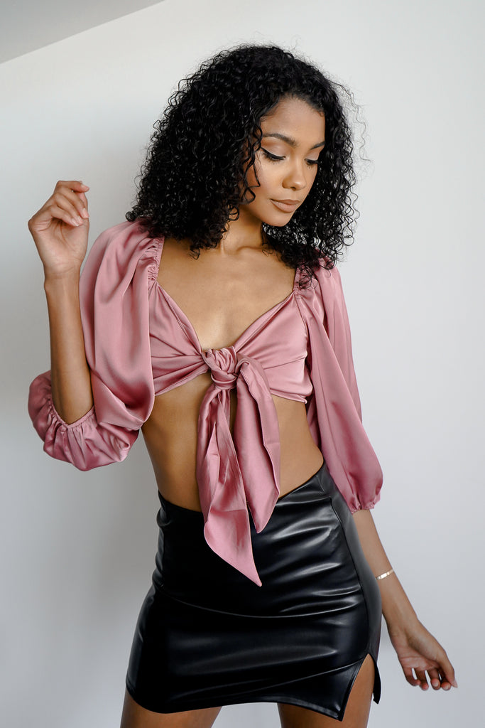A satin crop top featuring a self-tie front, V-neckline, and long sleeves.