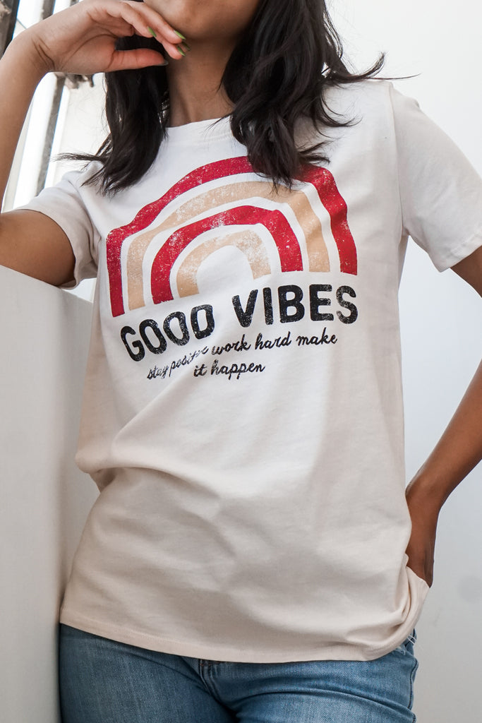 An oversized t-shirt featuring a graphic of a four-layer rainbow and text, 'Good Vibes,' and 'Stay positive work hard make it happen.' 