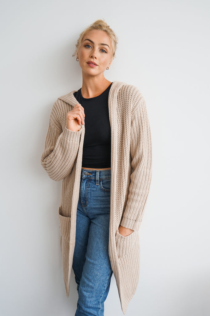 An oversized long cardigan featuring a hood, pockets, and long sleeves