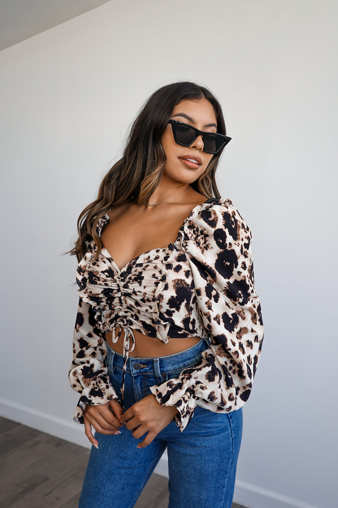 An allover animal print blouse featuring a sweetheart neckline, self-tie ruching and puff sleeves.