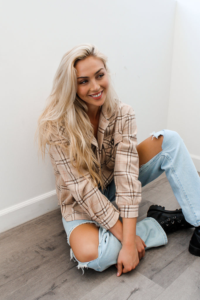 A button-up plaid jacket featuring a collar, long sleeves and pocket