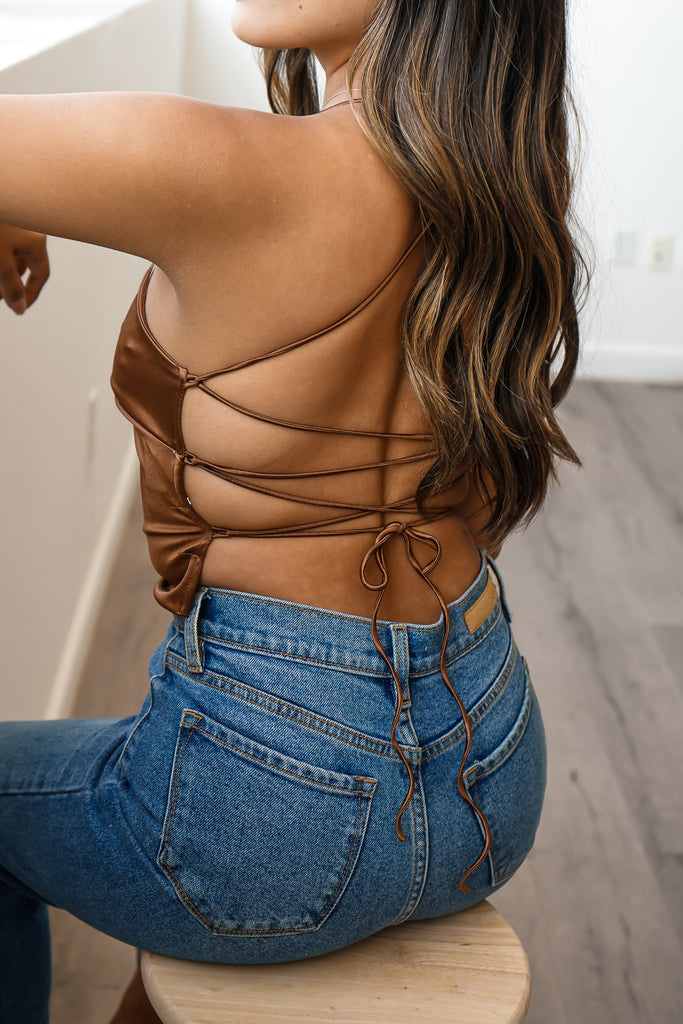 A crop top featuring cami straps, and an adjustable self-tie back.