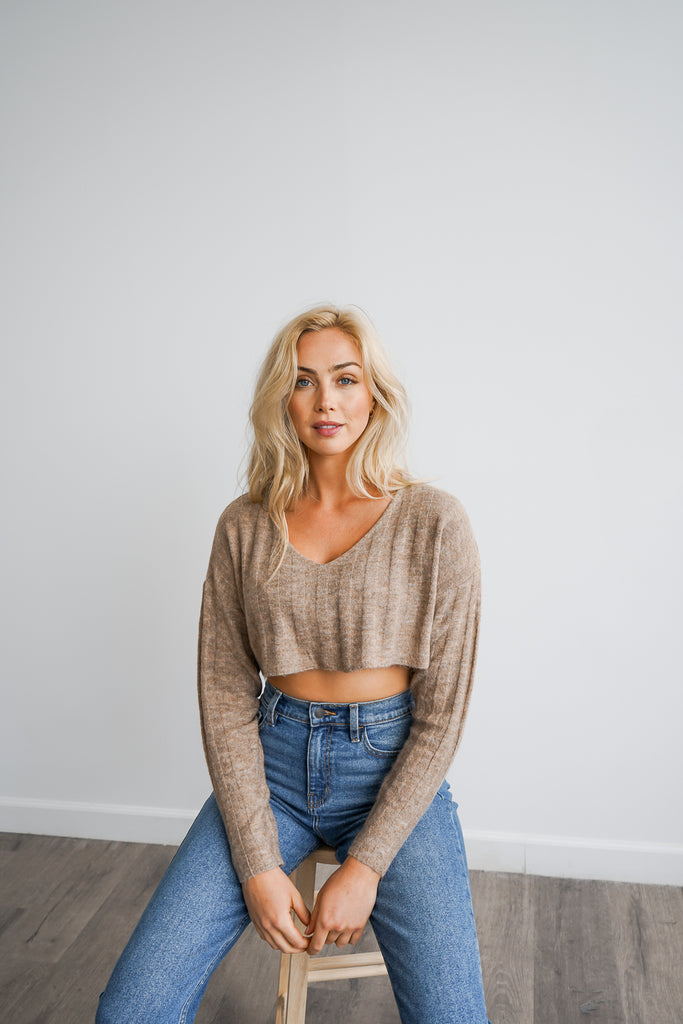 A cropped sweater featuring a v-neckline and long sleeves.