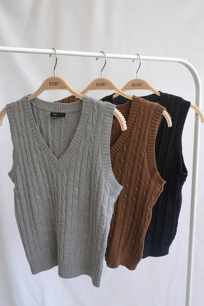 A woven sleeveless knit sweater vest featuring cable-knit stitching 