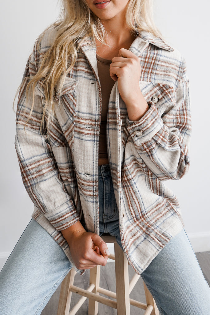 A plaid oversized button-up jacket featuring a collar, long sleeves and pockets.
