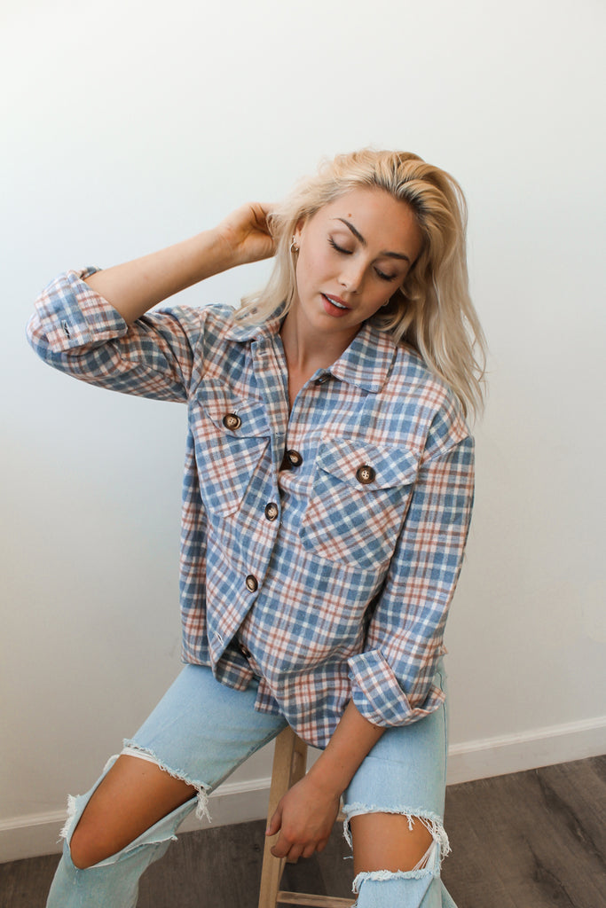 A button-up plaid jacket featuring a collar, long sleeves and pocket