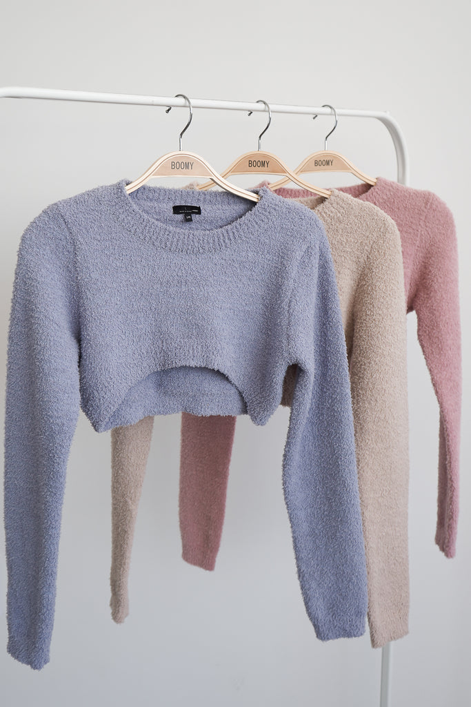 A cropped cozy sweater featuring a scoop neckline and long sleeves.