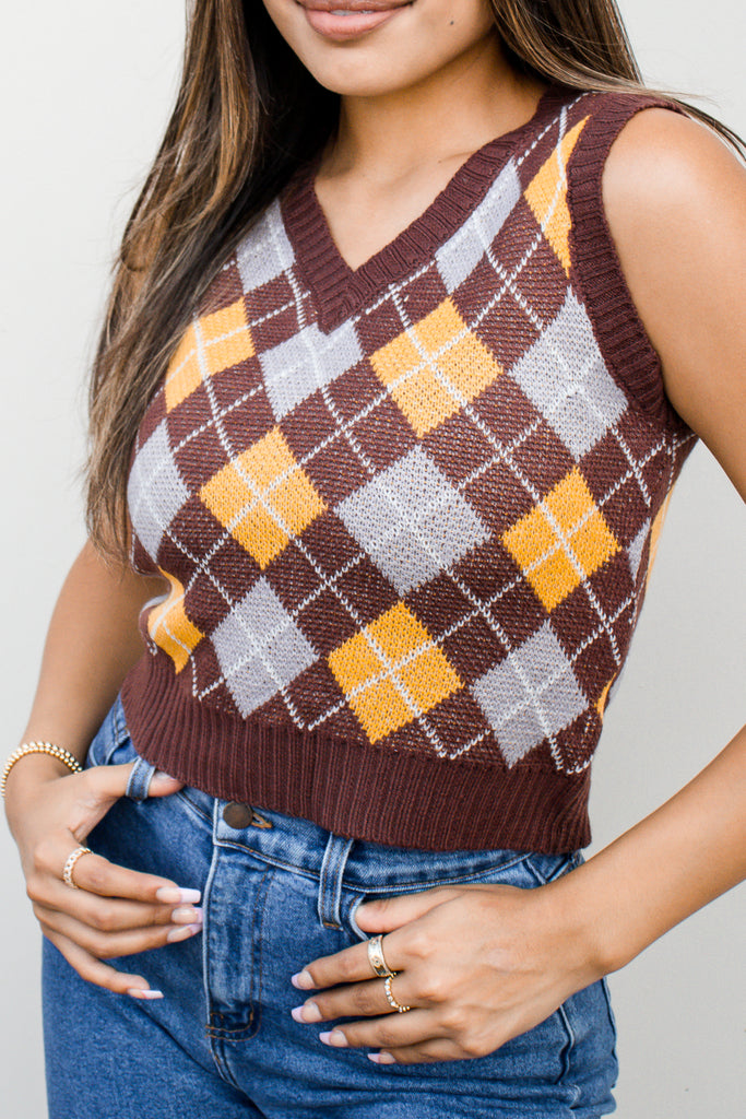 A woven knit sweater vest featuring an allover argyle pattern and v-neck.
