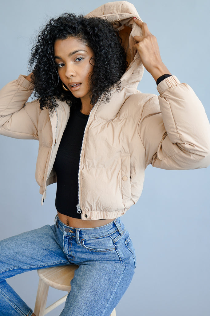 A cropped puffer jacket featuring a hood.