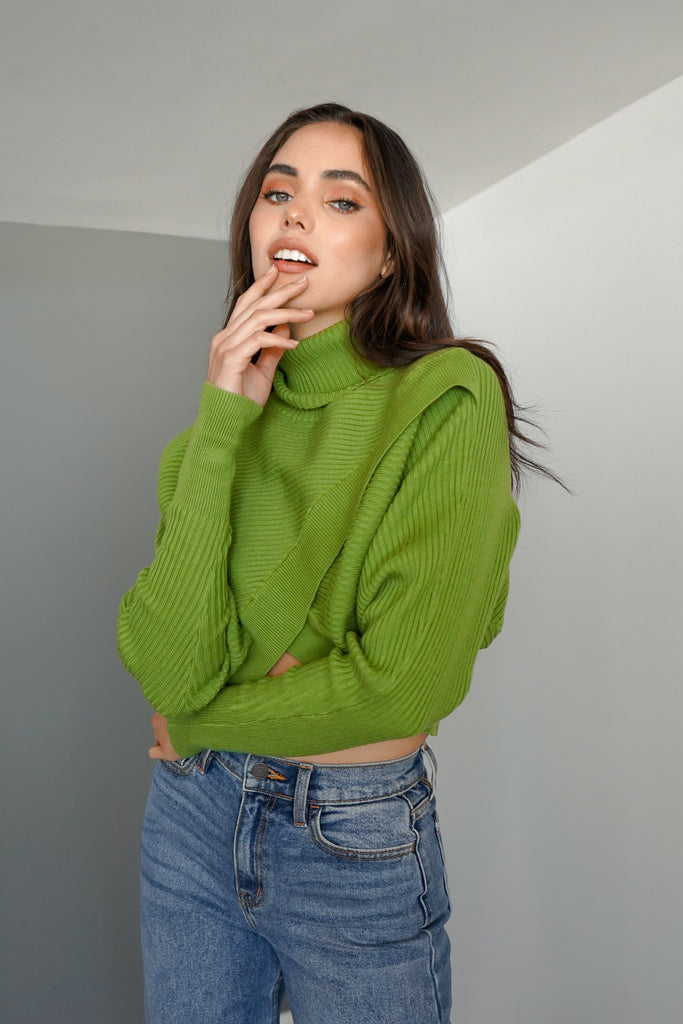 A cozy cropped turtleneck sweater with a cross front detail.
