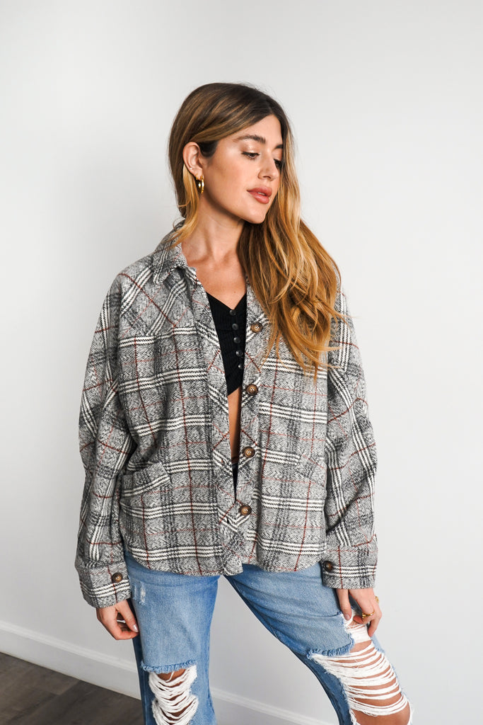 A plaid jacket featuring long sleeves, button-up in front and back, a collar, and pockets.