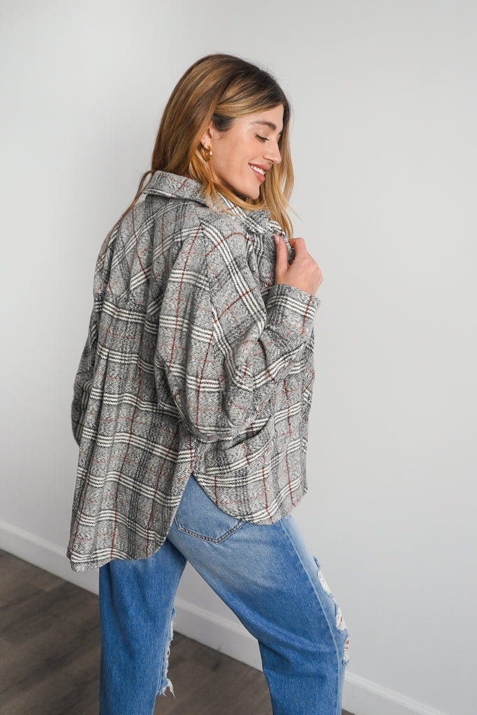 A plaid jacket featuring long sleeves, button-up in front and back, a collar, and pockets.