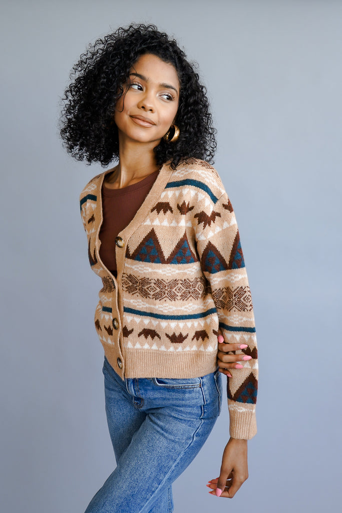 A cropped knit cardigan featuring a V-neckline, buttons in the front, and long sleeves.