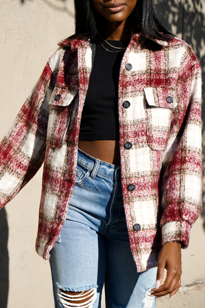A fuzzy button-up plaid jacket featuring a collar, long sleeves and pockets.