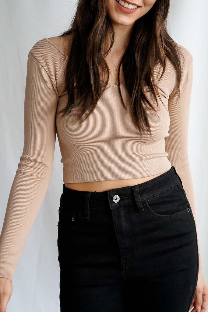 A ribbed knit long sleeve shoulder top featuring a v-neck.