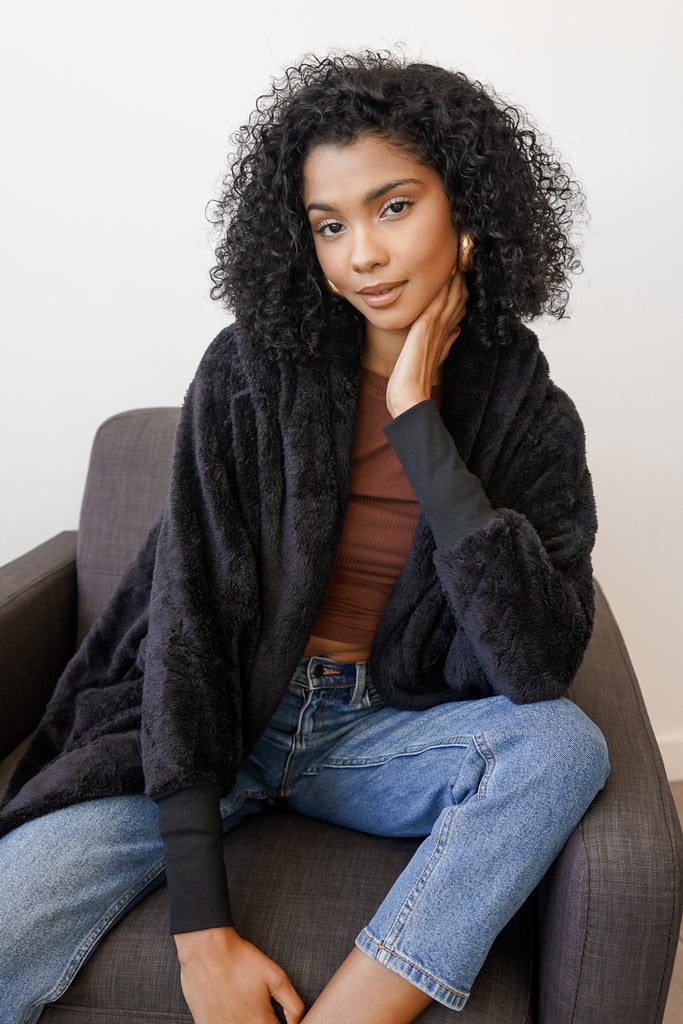 A faux shearling coat featuring a hood, open front, dropped shoulders, and long sleeves.
