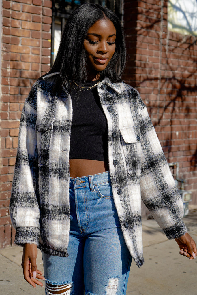 A fuzzy button-up plaid jacket featuring a collar, long sleeves and pockets.