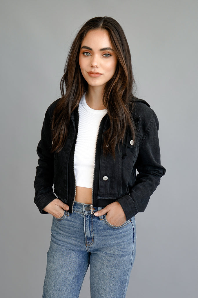A black denim jacket featuring a hood, button & zip front, long sleeves, collar, frayed hem, and pockets