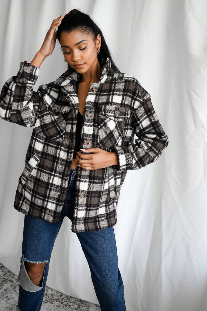 A sherpa plaid shacket featuring a collar, button-up front, and long sleeves.