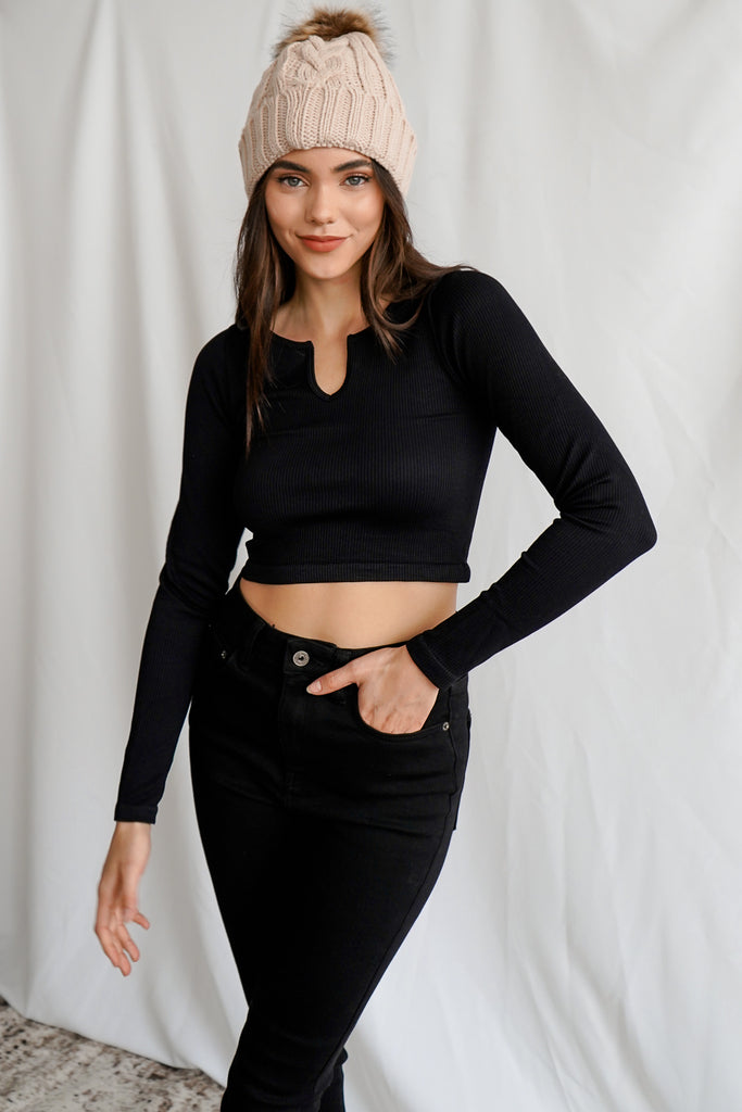 A ribbed sweater-knit top featuring a split neckline, long sleeves, and a cropped hem.