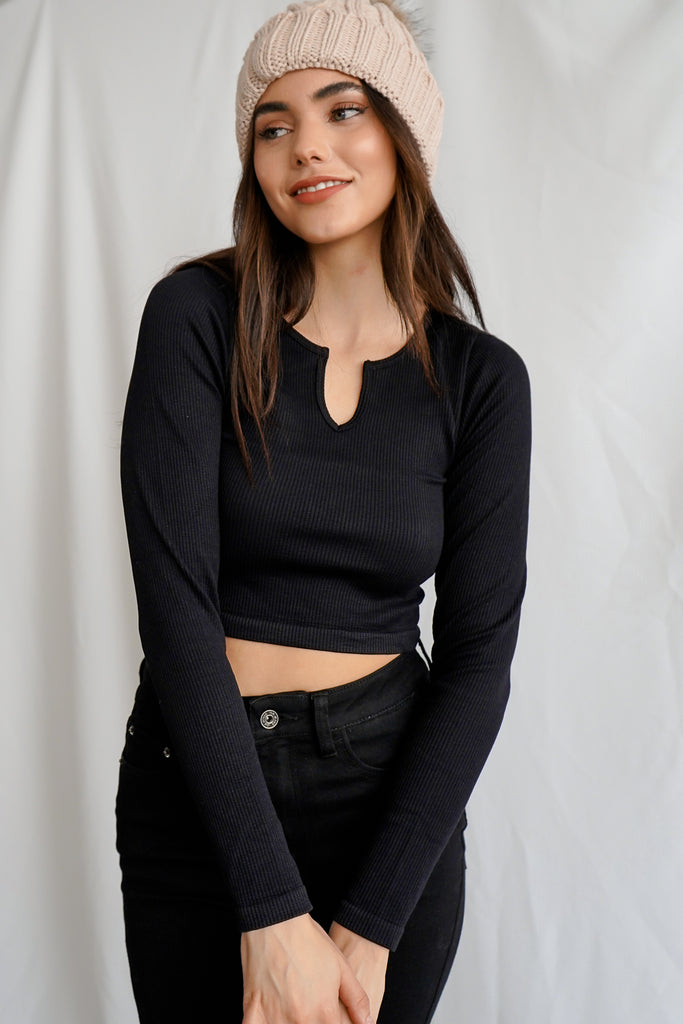 A ribbed sweater-knit top featuring a split neckline, long sleeves, and a cropped hem.