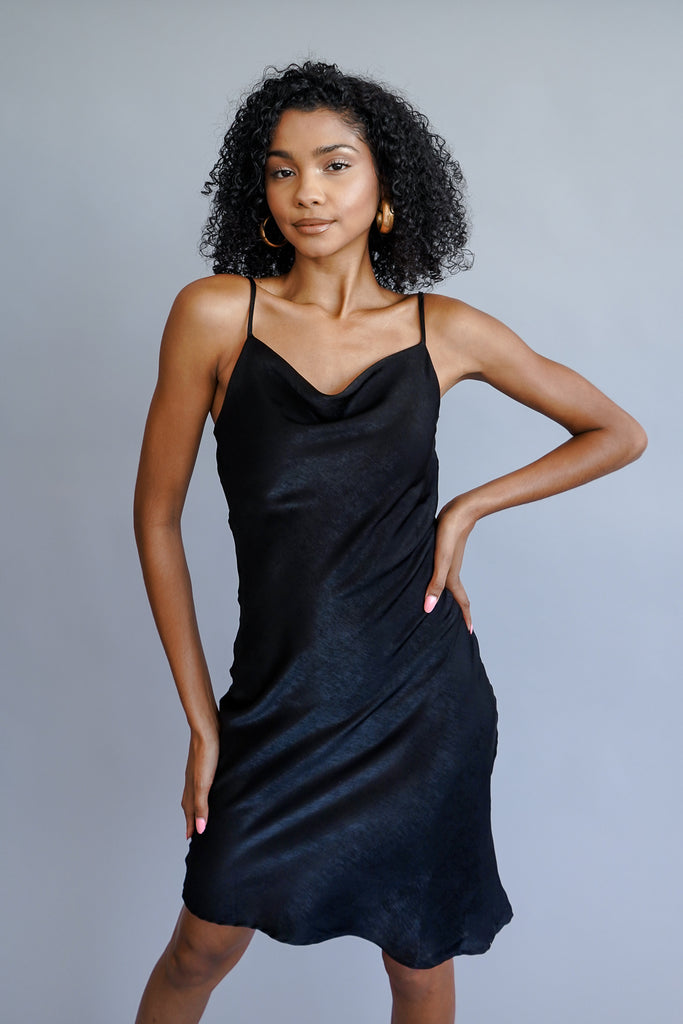 A midi dress featuring a cowl neck and cami straps. 