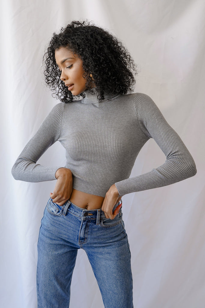 A ribbed knit top featuring long sleeves and a turtleneck.