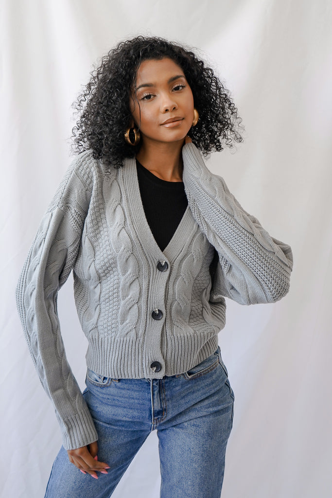 A soft knit sweater cardigan featuring long sleeves and a crew neck.