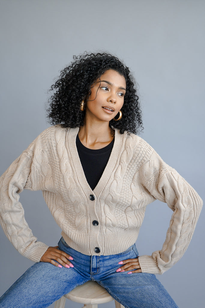 A soft knit sweater cardigan featuring long sleeves and a crew neck.
