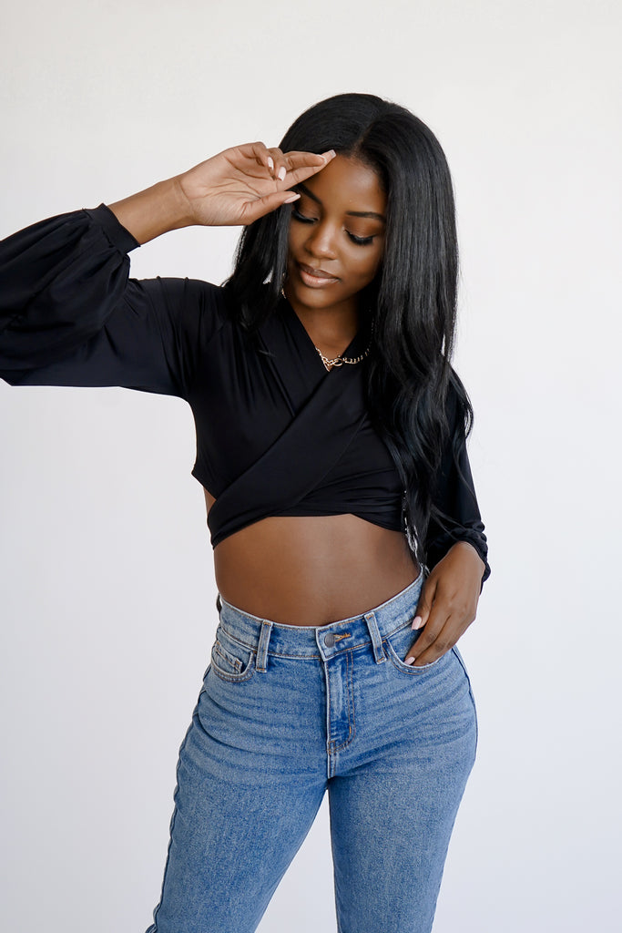 A satin crop top featuring a plunging V-neckline, long sleeves with shirred accents, and front self-tie closure.