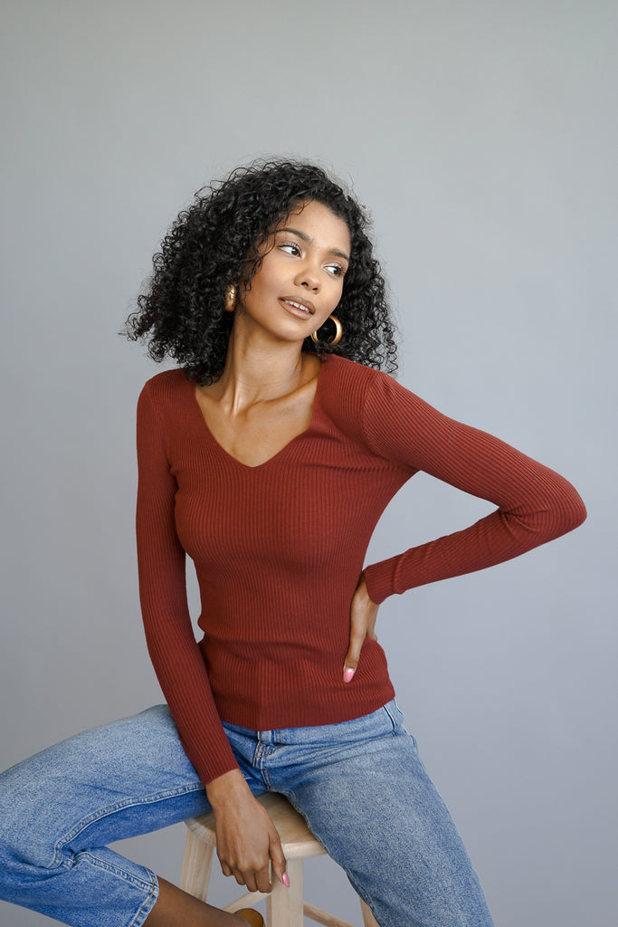 A basic ribbed knit sweater featuring a V-neckline and long sleeves.