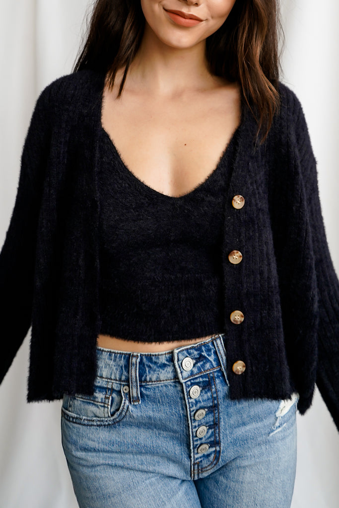 A two-piece fuzzy knit sweater-top featuring a cropped cami with straight neckline and attached fuzzy cardigan sweater with open front and long sleeves.