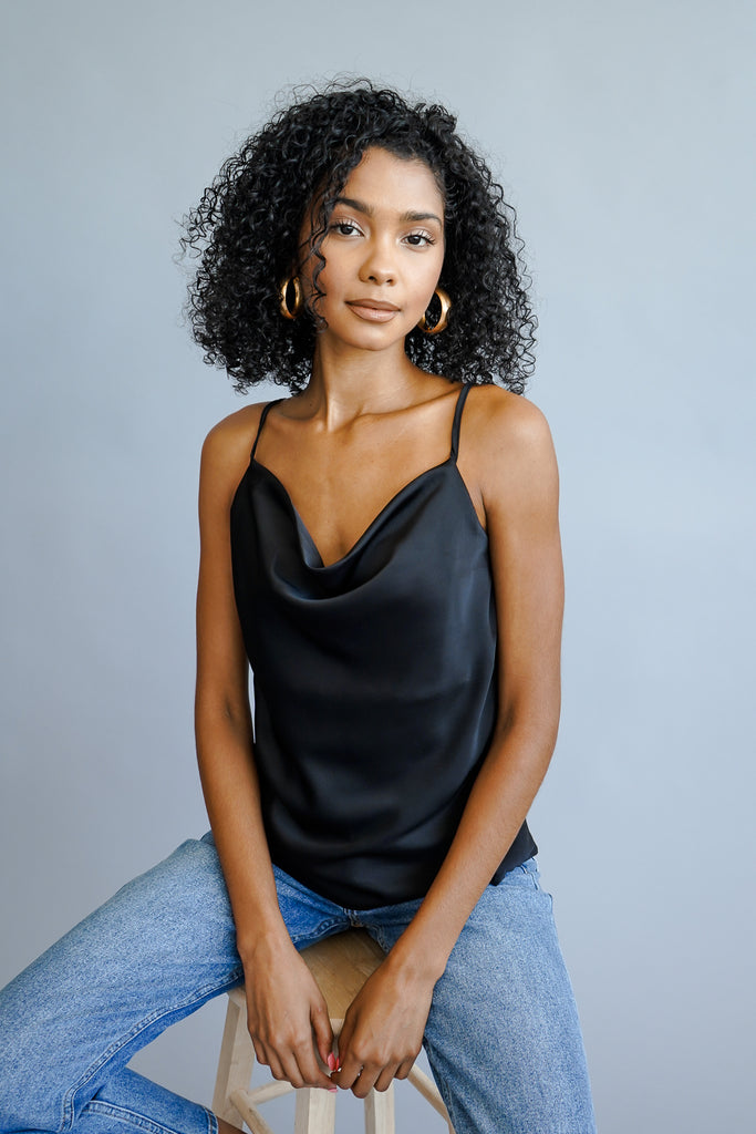 A satin cropped cami featuring a cowl neck and adjustable straps.