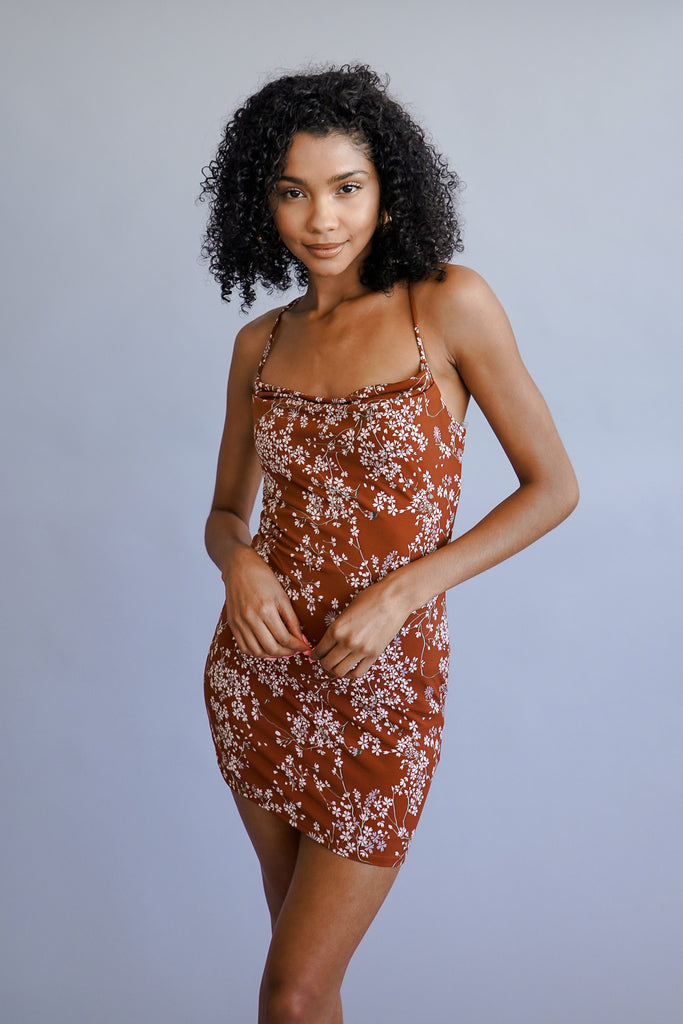 A mini sleeveless a-line dress featuring an allover mini-floral pattern, a cowl neck.