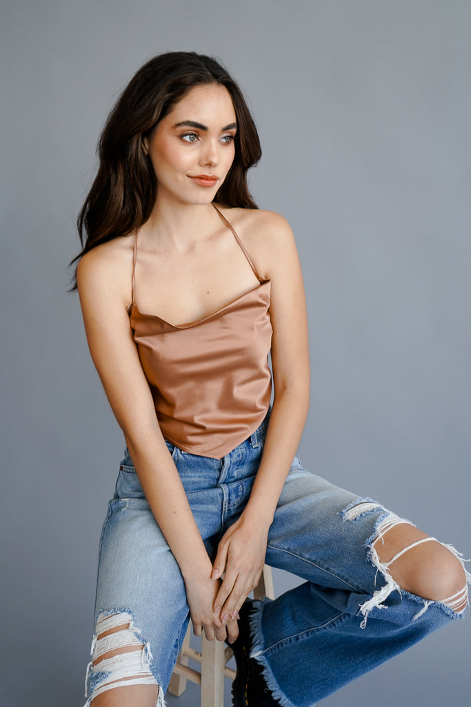 A crop top featuring halter straps, and an adjustable self-tie back.