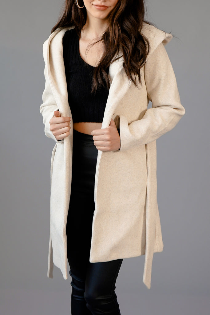 A belt wrapped coat featuring a hooded construction, long sleeves, and an open front.