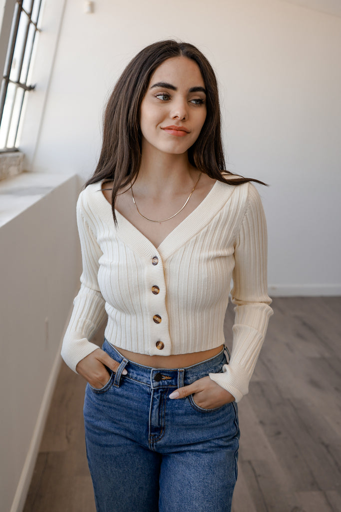A soft knit sweater featuring long sleeves, buttons and a v-neckline.