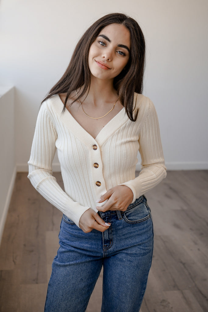 A soft knit sweater featuring long sleeves, buttons and a v-neckline.